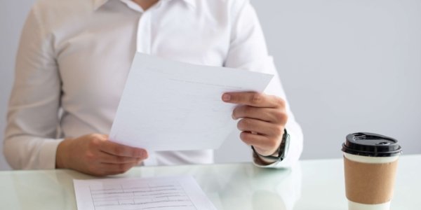 close-up-smiling-young-businessman-looking-document close-up-smiling-young-businessman-looking-document